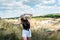 girl in casual cloth in a rural green field goes in summer