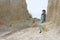 Girl in casual clothes sits with her leg dangling on a rock ledge