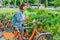 Girl with cell phone trying to rent a bicycle at bike sharing point in the city