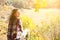 Girl in the checkered shirt is sitting in the autumn forest. Seasonal concept. Stylish hipster clothes outdoors. Nature philosophy