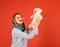 Girl with cheerful face holds soft toy on red background