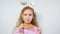 The girl cheerfully nibbles carrot pieces on a stick. Child with bunny ears eating carrot