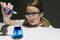Girl chemist in the laboratory conducts an experiment