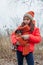 Girl and chihuahua in winter clothes. Teenager girl in an orange jacket, hat and scarf. chihuahua