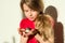 Girl child 7 years old blonde with long wavy hair holds in the hands of her beloved pet - hamster.