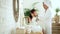 Girl child in bathroom brushing long black hair with mother Spbd. Asian woman in robe comb kid