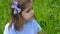 Girl child in a blue striped dress and a bow stands