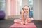 Girl child doing fitness exercises in health club, stretching in exercise