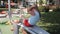 Girl child engaged in workout on street exercise equipment in the summer in the park.