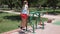 Girl child engaged in workout on street exercise equipment in the summer in the park.