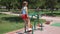 Girl child engaged in workout on street exercise equipment in the summer in the park.
