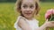 Girl child four years old stands in a field in a straw hat in a field