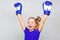 Girl child happy winner with boxing gloves posing on grey background. Feminist movement. She feels as winner. Upbringing