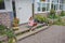 The girl child with a laptop is sitting on the porch of the house during a lesson on a remote photo without a filter