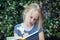 Girl child with notebook outdoors portrait. Girl writing