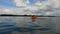 Girl child in an orange life jacket is bathing in the water