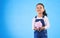 Girl child, piggy bank and studio portrait with mockup space, saving and financial education by blue background. Female