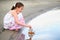 Girl child playing with a toy sailing ship by the river