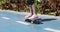 Girl child rides skateboard down street in sunny weather