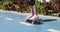 Girl child rides skateboard down street in sunny weather