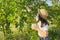 Girl child tearing from tree harvest of mulberries in mug in home garden