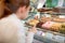 Girl choose macarons in confectionary store