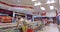 Girl chooses goods and meal in the supermarket. Shopping in the store. Young female is carefully analyzing products in a market.