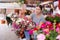 Girl choosing flowering petunias in hanging cache-pots at flower market