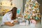 Girl at Christmas dreams near the Christmas tree with gifts, the