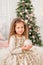 Girl with a Christmas toy in her hands. Portrait of a child with a Christmas ball