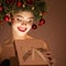 Girl with christmas wreath on her head. Open magic gift box
