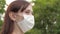 Girl on city street travels in medical mask. protective mask on face of a young girl outdoors in Park. female tourist