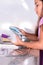 Girl cleaning a glass with a loofah in the kitchen sink. Helping with the housework. Vertical photography