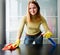 Girl cleaning table with furniture polish at home