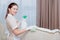 A girl in a cleaning uniform wipes or cleans upholstered furniture. Cleaning service at the hotel. The concept of the hotel