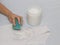 A girl cleans a stain with a sponge on a T-shirt using a stain remover, close-up, hand