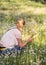 A girl in a clearing with lush white fluffy dandelions