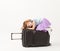 The girl climbed on suitcase on white background