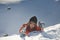 Girl climber climbs a snow cornice using ice axes through snow blown away by the strong wind.