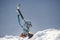 Girl climber climbs a snow cornice using ice axes through snow blown away by the strong wind.