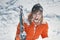 Girl climber climbs a snow cornice using ice axes through snow blown away by the strong wind.