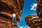 Girl Climber practicing bouldering on a beautiful red rock in Ca