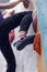 Girl climbing up on wall in gym, focus on feet