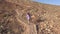 Girl climbs up a slope of a mountain