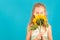 Girl with closed eyes smelling a sunflower