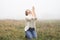 Girl closed her eyes on the knees, praying in a field during beautiful fog.