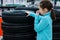 The girl closes her nose from the unpleasant smell of rubber, tires on the shop window for sale