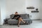 girl in clothes enchantingly posing on the background of a brand new sofa in the apartment.