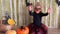 Girl with clown glasses waving hands during Halloween celebration.