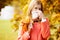 Girl with cold rhinitis on autumn background. Fall flu season. I